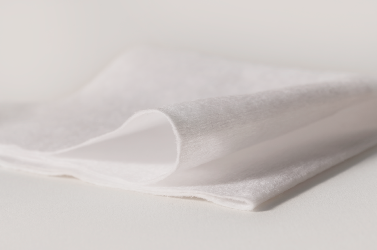 Close-up of white fabric with a subtle texture on a light gray background